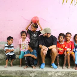 Voyageur assis au côté d'enfants à Flores.