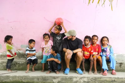 Voyageur assis au côté d'enfants à Flores.